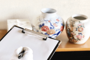 査定するお品の内容を紙に書くスタッフ